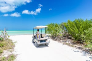 Photo of a Man Driving a Port Aransas Golf Cart Rental Along the Beach.